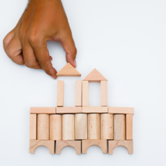 Business strategy concept on white background flat lay. man building castle from wooden blocks.