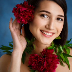 Picture of tender young girl with flowers over blue background