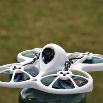 A closeup of a quadcopter in the blurred background