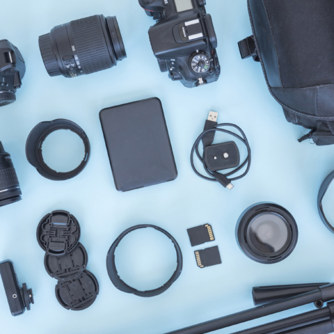 professional-photographer-accessories-equipments-arranged-blue-backdrop