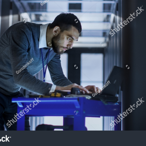 stock-photo-it-engineer-with-tool-cart-working-on-a-laptop-computer-he-deploys-new-software-he-stands-at-a-662881918