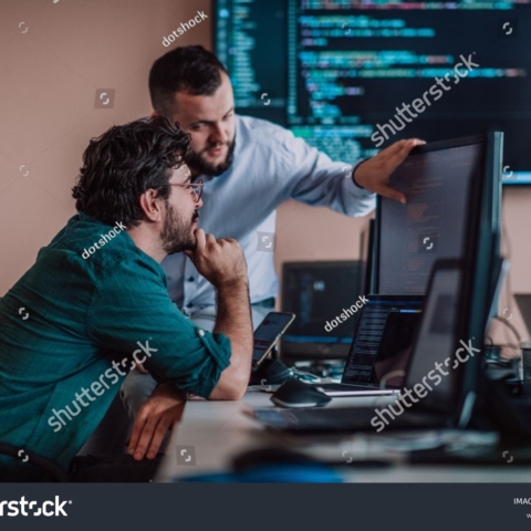 stock-photo-programmers-engrossed-in-deep-collaboration-diligently-working-together-to-solve-complex-problems-2311435427