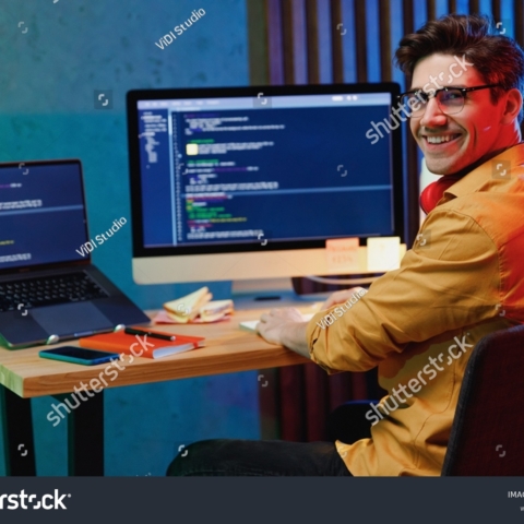 stock-photo-side-back-view-smiling-young-full-stack-developer-software-engineer-it-specialist-programmer-man-in-2169841789