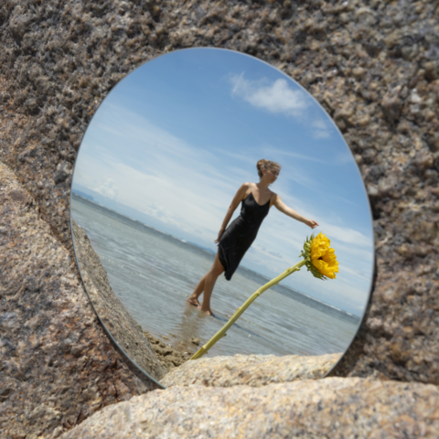 woman-posing-with-round-mirror-flower