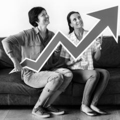 Women holding statistics icon board sitting on couch